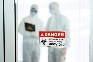 Covid19 - two people - dressed in protective suits -cdc