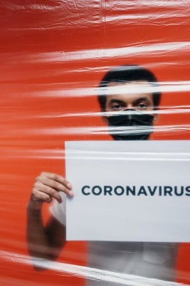 college student holding coronavirus (COVID-19) sign with blood red background