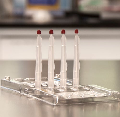 Die Mitra®-Schale mit 4 Probenentnahmespitzen in einem Laborumfeld 
