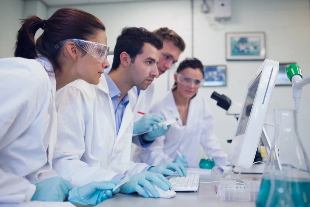 Side view of serious researchers looking at computer screen in the laboratory -v2