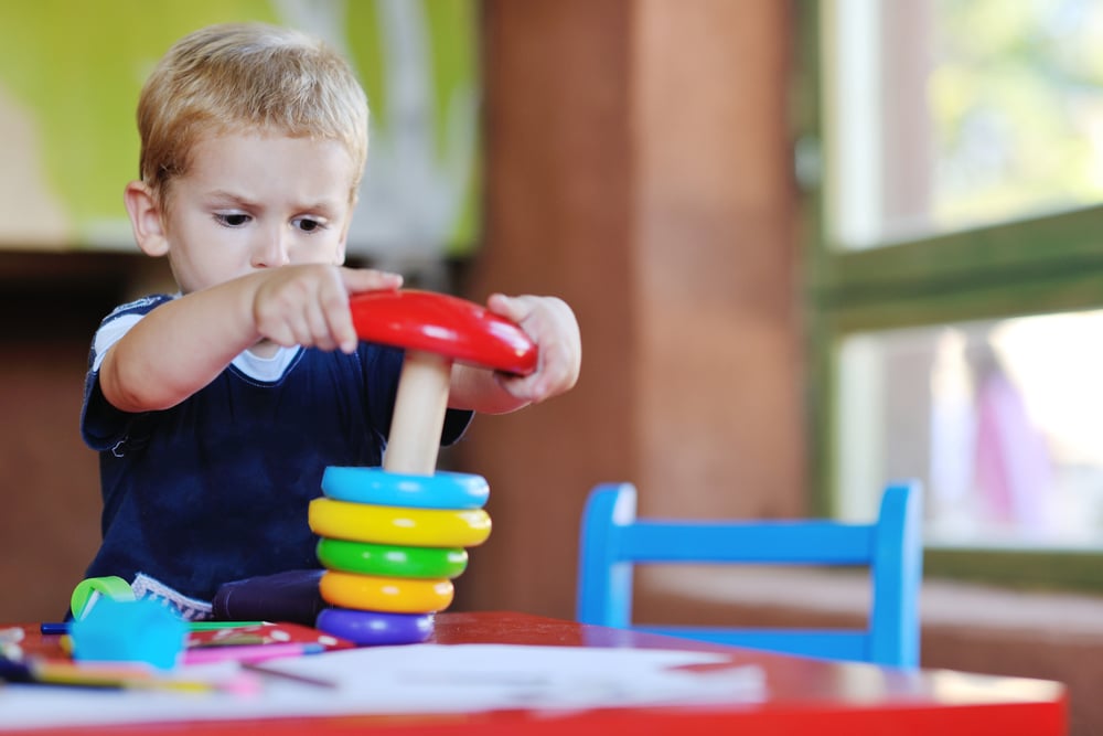 happy little child play game and have fun, education lessons in colorful kinder garden playground indoors