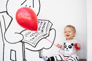 pediatrics young child holding a red baloon waiting for doctor check-up appointment