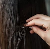close up of a hair sample bbeing taken from long brown hair