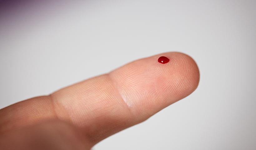 close up photo of a blood drop on a finger tip
