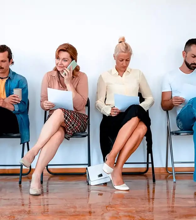 a room of men and women sitting in a waiting room