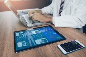 doctor on laptop using remote patient monitoring devices