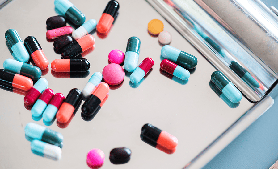 various pills are scattered over a table surface.