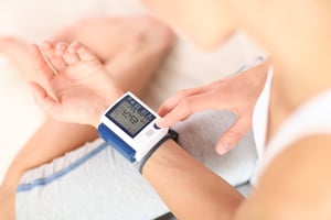 A small heart rate monitor machine around a young mans wrist