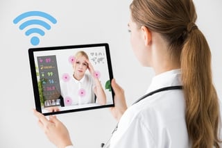 a female doctor speaks via her laptop video to a sick patient at home.