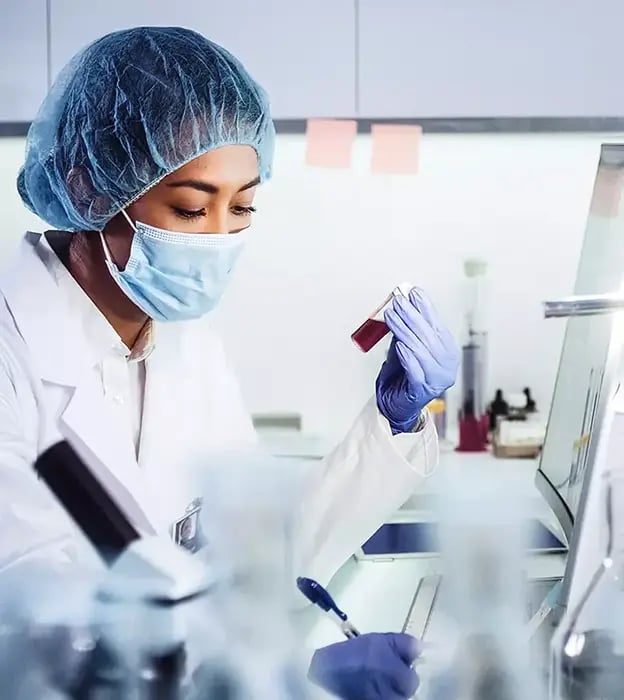 a scientist in a laboratory holding a glass container