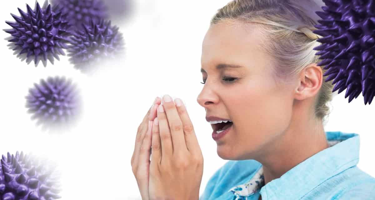 Blonde woman sneezing with hands in front of her face against virus or coronavirus sars-cov-2 and antibodies