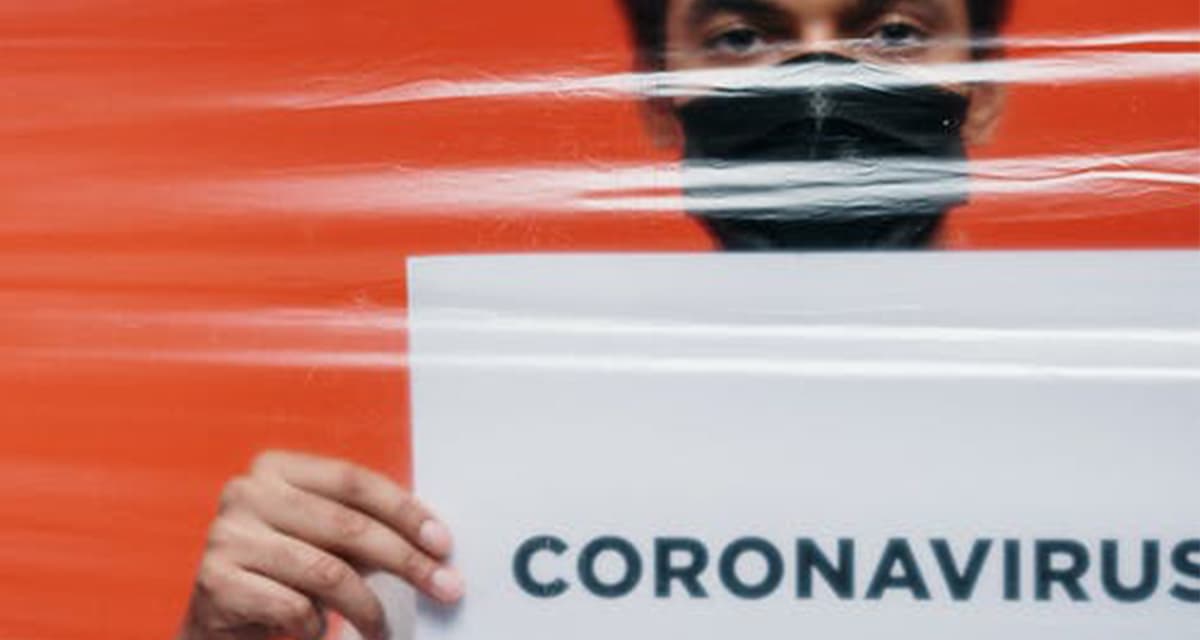 college student holding coronavirus (COVID-19) sign