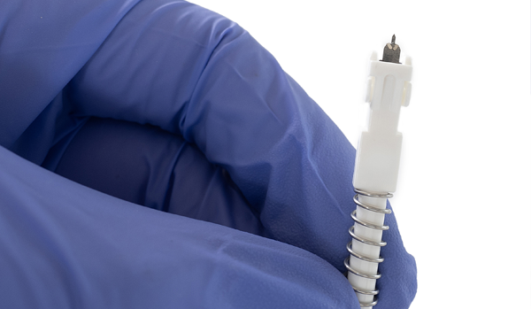 A gloved hand holds the Harpera needle after its been removed from its housingl 