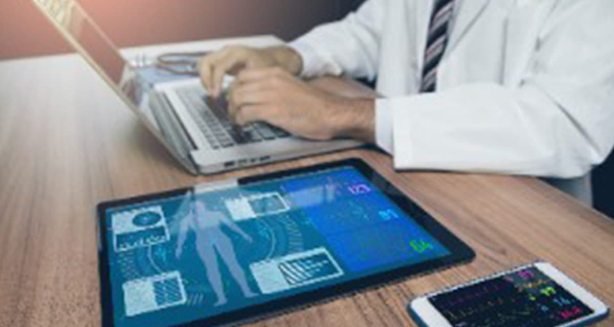 doctor on laptop using remote patient monitoring devices